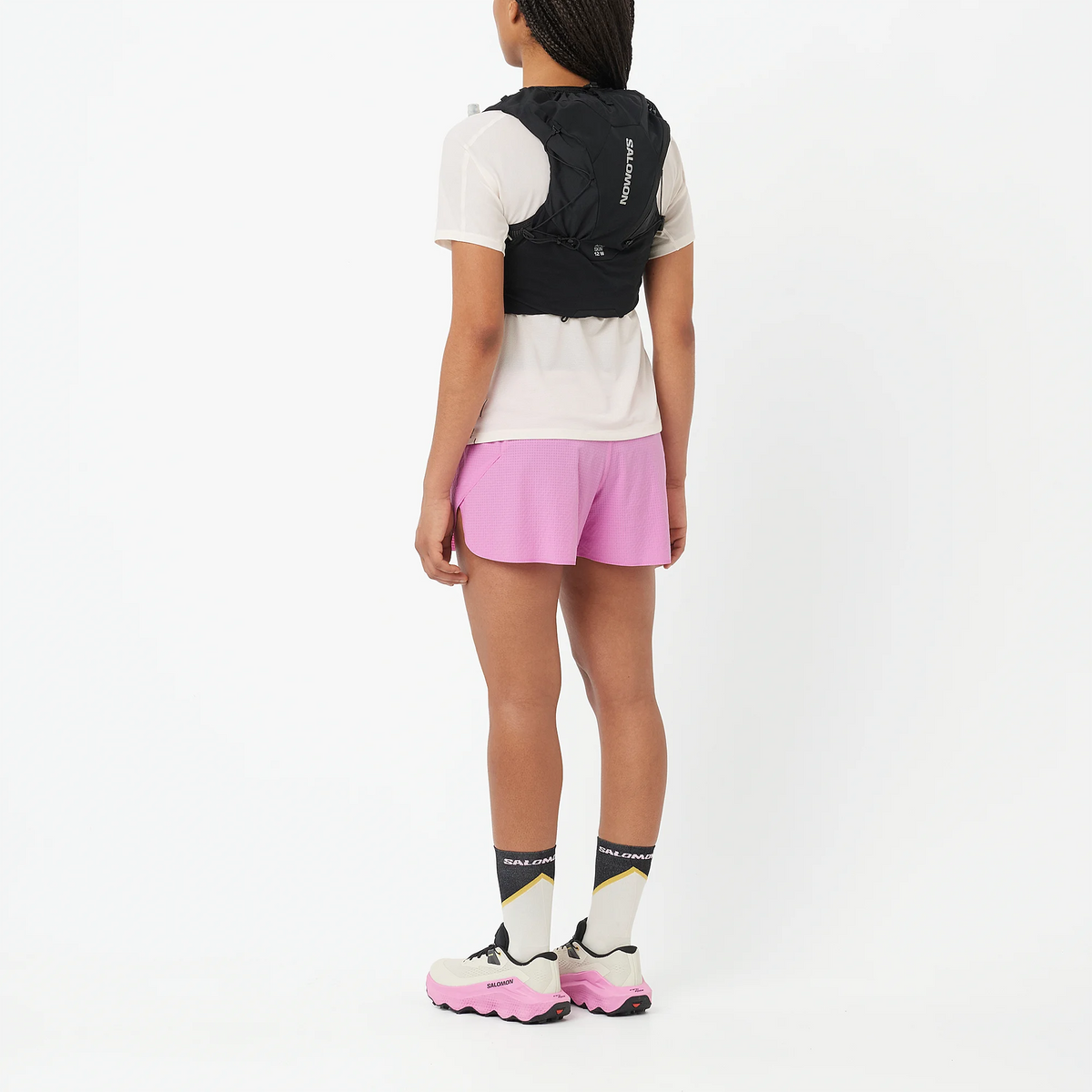 Hydratatievest Salomon ADV Skin 12 Women zwart gedragen door een hardloopster, achteraanzicht van het hele lichaam